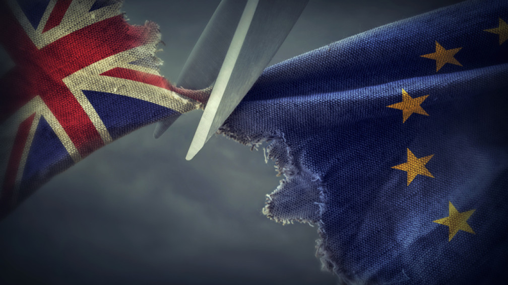 Eine Schere schneidet die EU-Flagge und die Flagge von Grossbritannien auseinander.