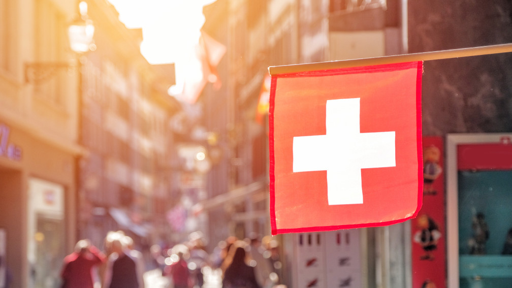 Schweizer Flagge im Vordergrund der Stadt