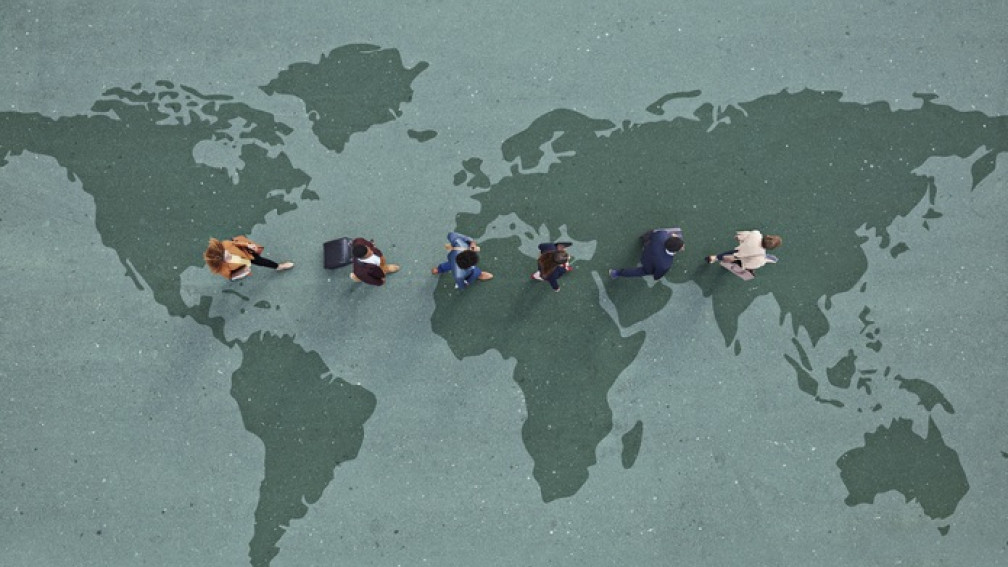 Junge Businessleute laufen über auf den Boden gezeichnete grüne Weltkarte