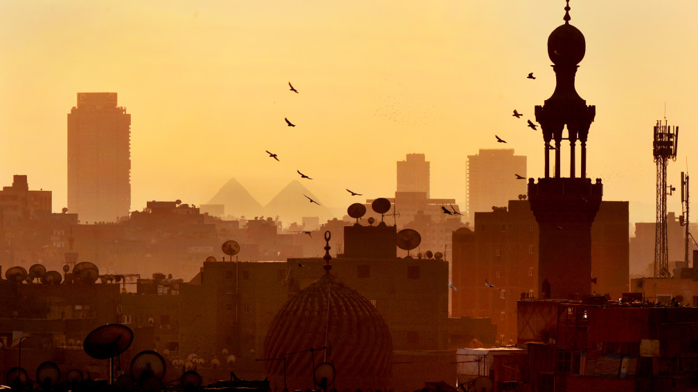 Die Skyline Kairos im Sonnenuntergang - Vögel fliegen am Himmel