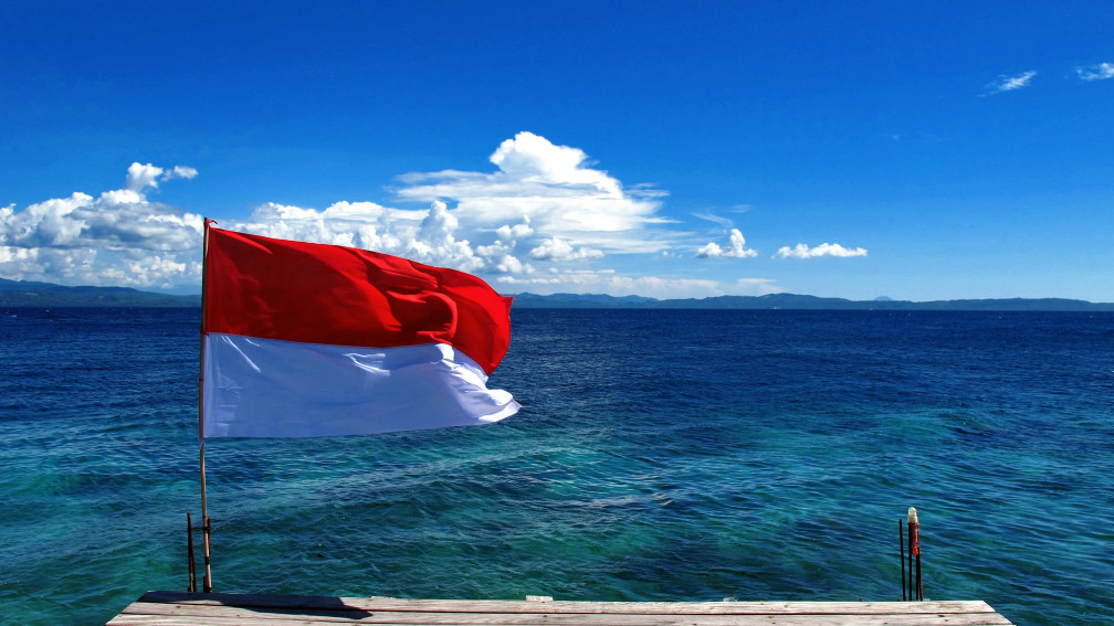 Flagge Indonesiens vor Meer und klarem Himmel