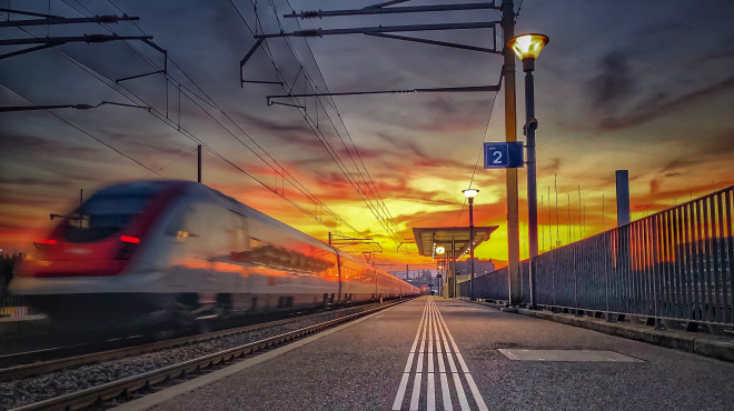 Passaggio di treno veloce in stazione al tramonto