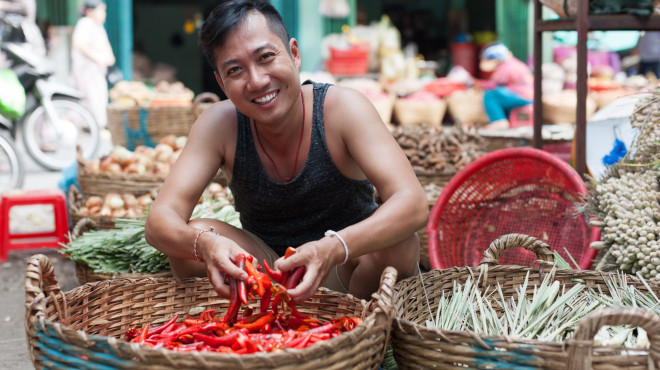 Indonesischer Mann verkauft Chilis auf dem Markt