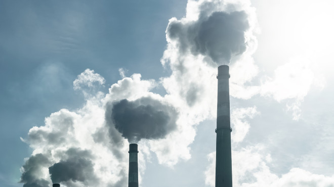 Industrieschornsteine die Rauchwolken in die Umwelt ablassen