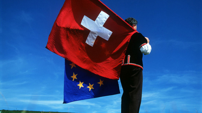 Mann schwingt Schweizer und EU-Fahne
