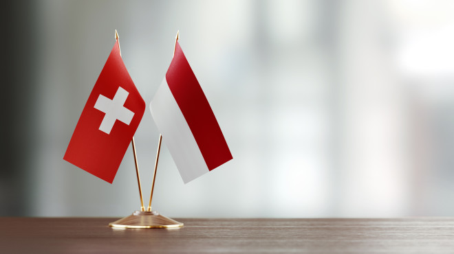 Flaggen der Schweiz und Indonesiens auf einem Tisch nebeneinander