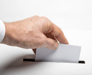 Mann wirft Stimmzettel ein