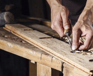 Hände, die Nägel auf dem Holzbrett sortieren