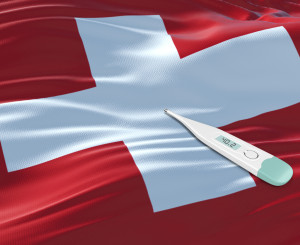 Fiebermesser mit hoher Temperatur liegt auf Schweizer Flagge