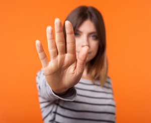 Woman holds out hand, signalling "stop"