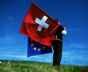 Mann schwingt EU und Schweizer Fahne