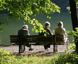 Drei Personen sitzen auf einer Bank