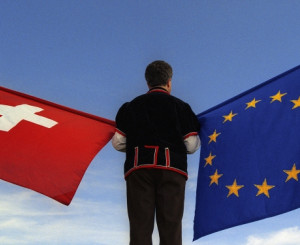 Mann schwingt EU und Schweizer Fahne